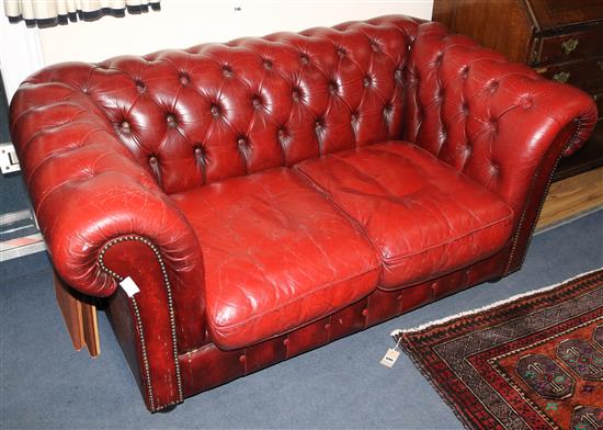 A buttoned red leather Chesterfield, W.150cm